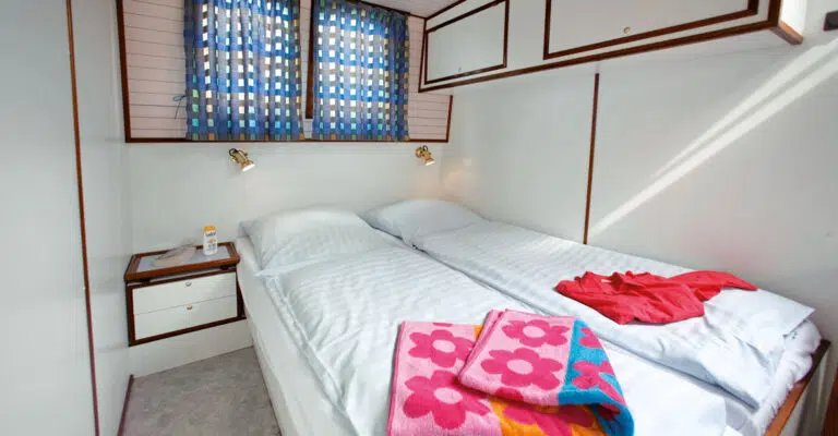 Ein bezogenes Doppelbett einer Kormoran mit weißen Bettbezügen.