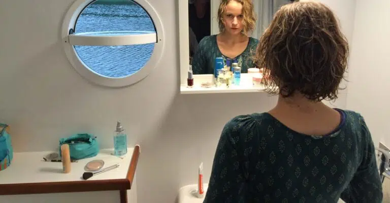 Eine Frau im bad eines Febomobils guckt in den Spiegel
