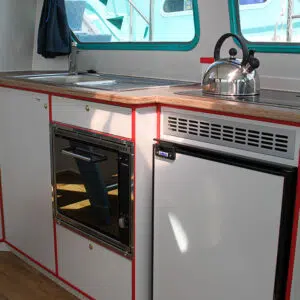 Die Küchenzeile der Pirate 915 mit Gasherd, Spüle, Backofen und Kühlschrank.