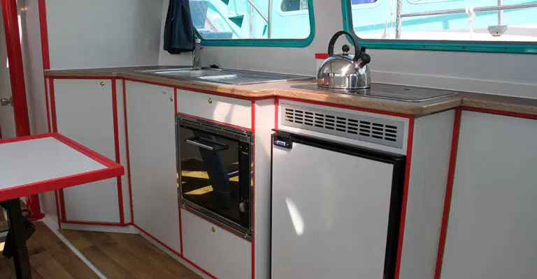 Die Küchenzeile der Pirate 915 mit Gasherd, Spüle, Backofen und Kühlschrank.