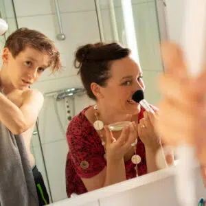 Zwei Personen im Badezimmer eines Pedro H2Home. Eine Frau schminkt sich und ein Junge föhnt sich die Haare.
