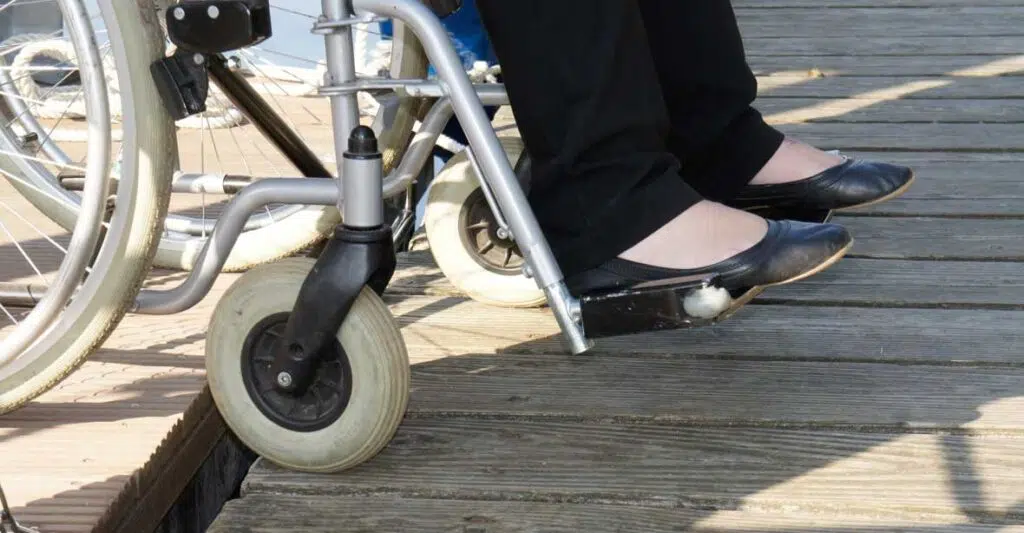 Eine Rollstuhlfahrerin fährt von einem Febomobil direkt auf den Steg