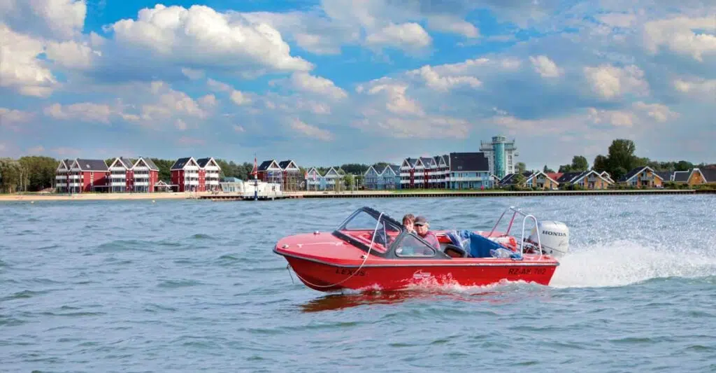 Ein Rotes Sportboot vor dem Hafendorf Müritz.