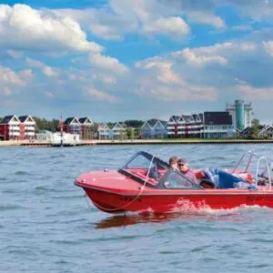 Ein Rotes Sportboot vor dem Hafendorf Müritz.