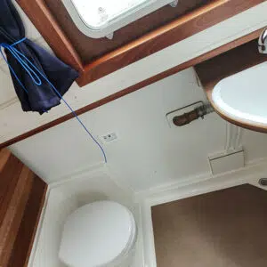 Badezimmer der Kuinder und Waschbecken mit beweglichem Duschkopf. Die Toilette kann abgedeckt werden mit einer Platte in Holzoptik.