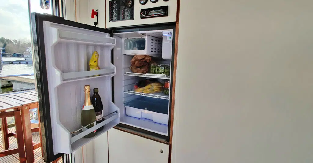 Ein voller Kühlschrank im Saunahausboot mit Gemüse- und Gefrierfach.